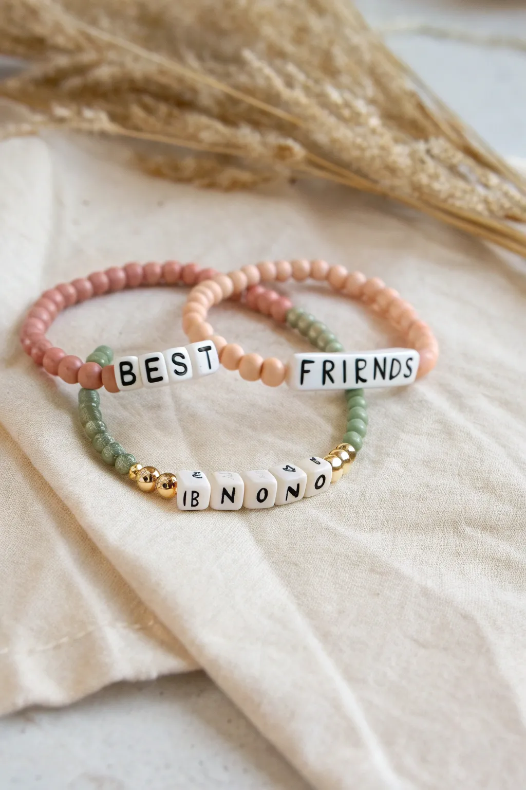 A sweet best friends bracelet duo with matching clay heishi colors and split phrase letter beads.