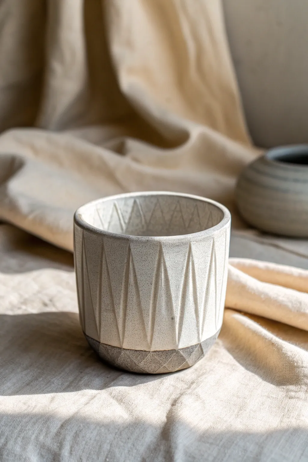Faceted pottery with carved texture bands and a soft glaze break for calm, modern contrast