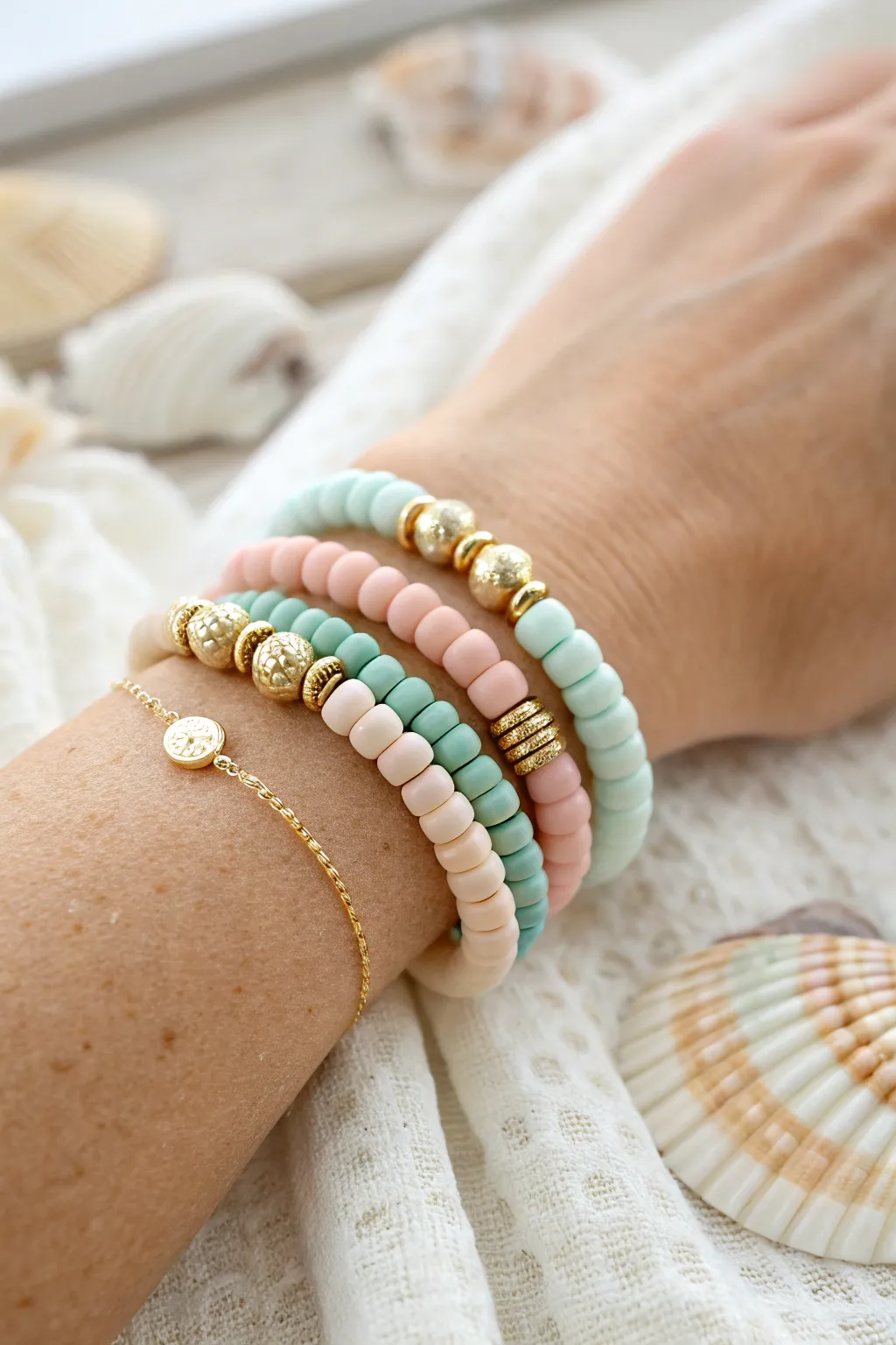 Tiny clay discs and gold spacers create a bright, preppy beach stack with clean minimalist contrast.