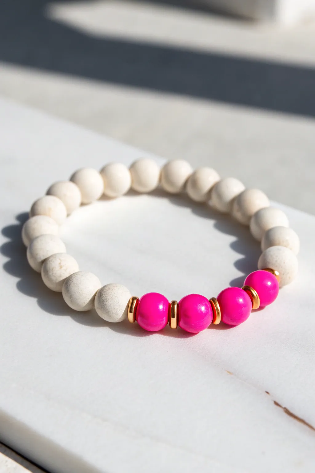 Clean white clay beads with a hot pink twist and gold spacers for a crisp preppy pop.