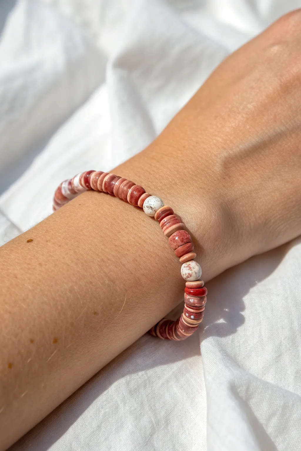 Marbled red clay disc beads bring earthy warmth to a minimalist heishi bracelet.