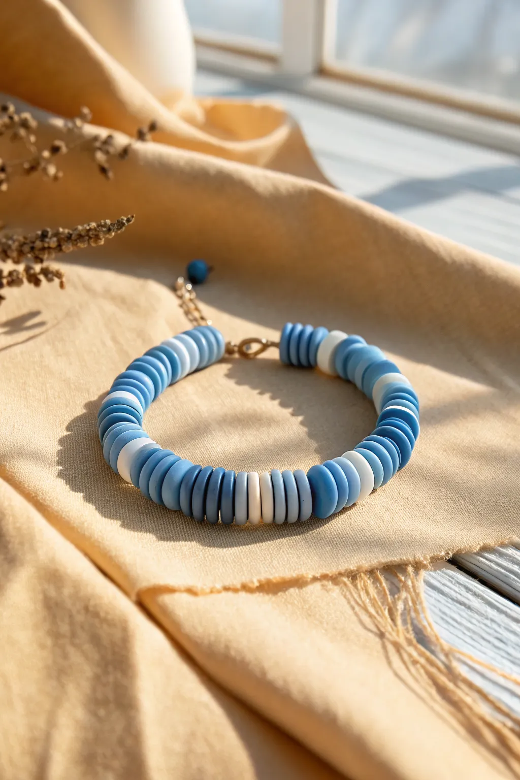 Two-blue stitch wave clay disc bracelet on linen, minimalist boho style in soft daylight.