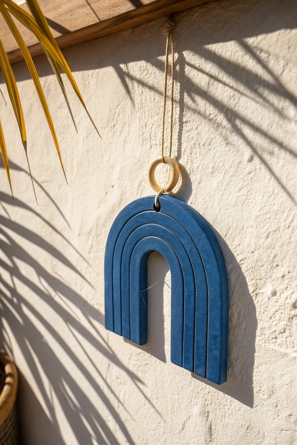 Minimal arch-cutout air-dry clay hanging casting crisp shadows for modern boho walls