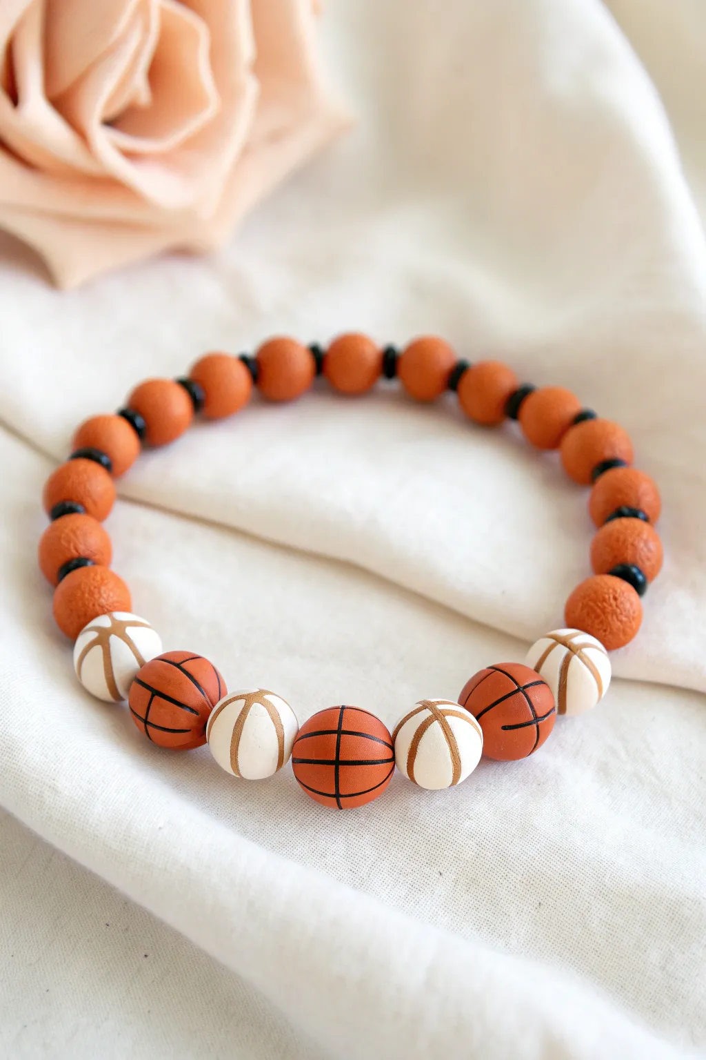 Orange clay basketball disc beads with sleek black lines for a clean, bold bracelet look.