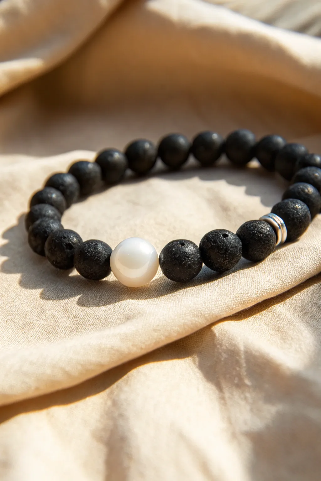 A minimalist black and white clay bracelet with one glossy pearl for a quiet statement.