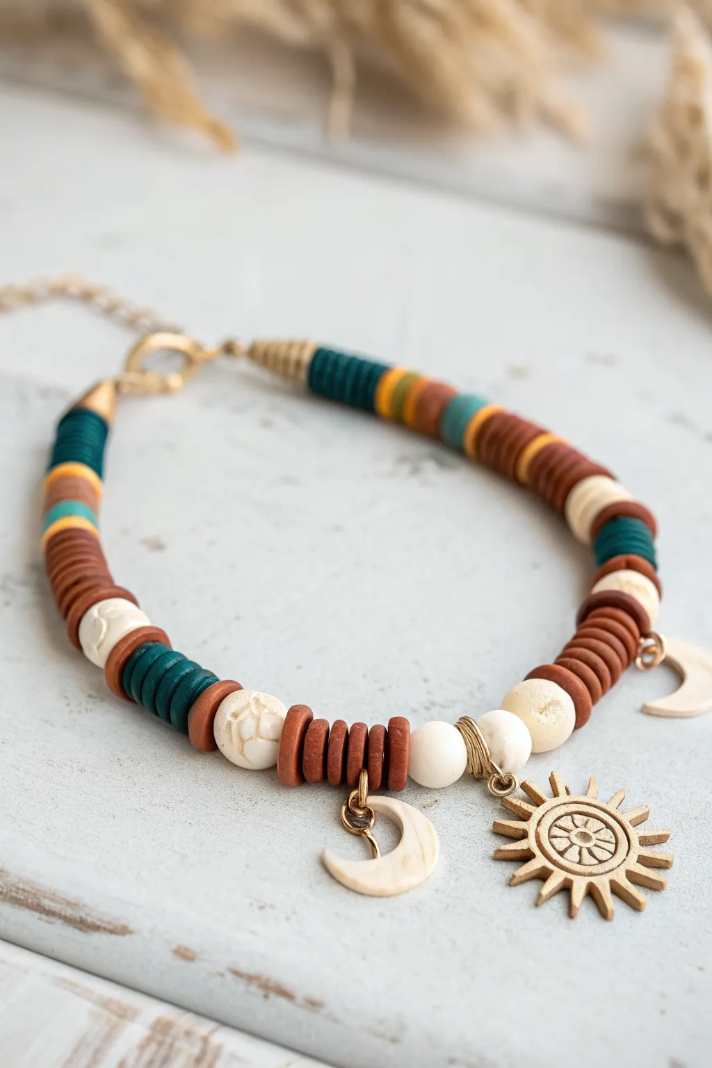 Crescent and sun clay bead bracelet with bold heishi discs, warm light, and clean boho minimal style.