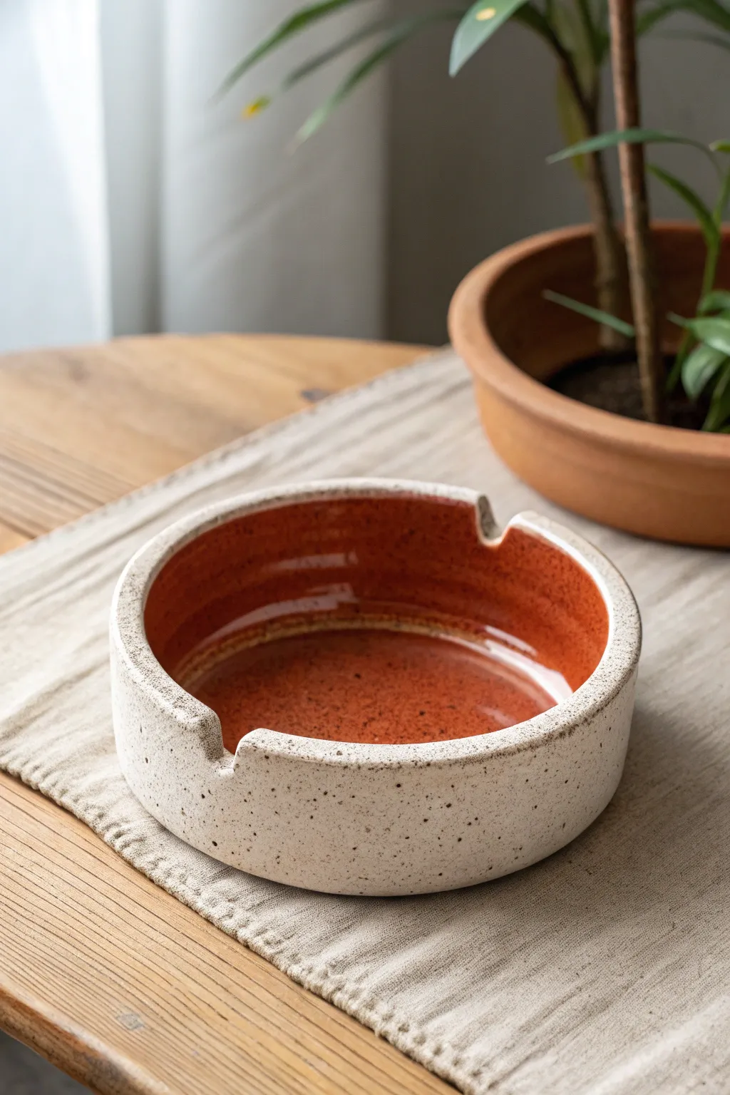Minimal ceramic ashtray with a built-in match strike strip and bold terracotta contrast.