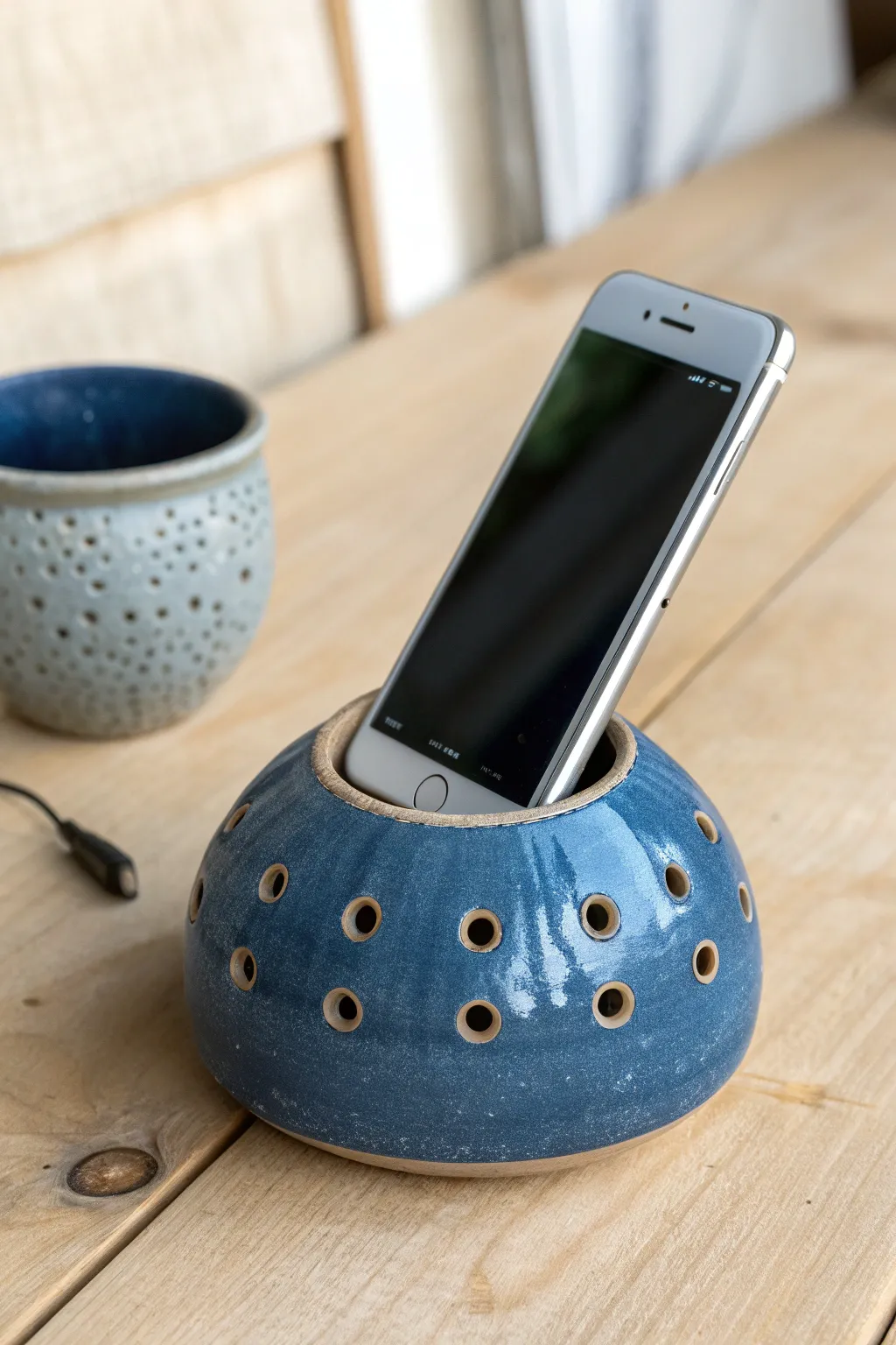Lantern-style perforated ceramic amplifier pod with bold sound opening, minimalist and boho.