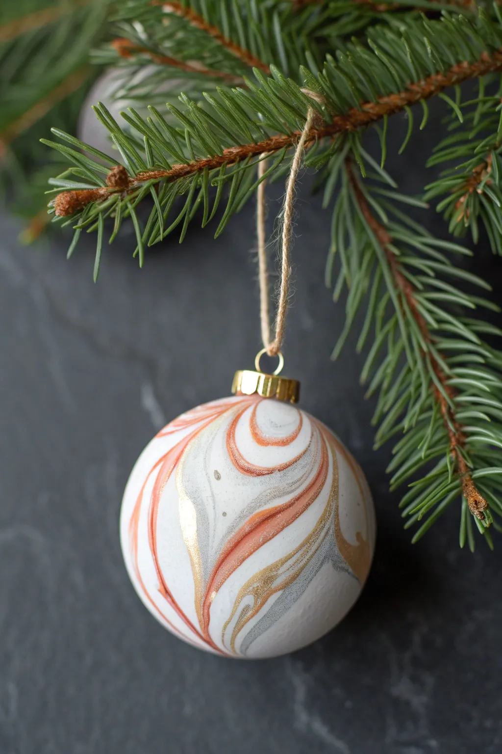 Modern marbled clay ornament with metallic accents for a chic minimalist Christmas tree look.