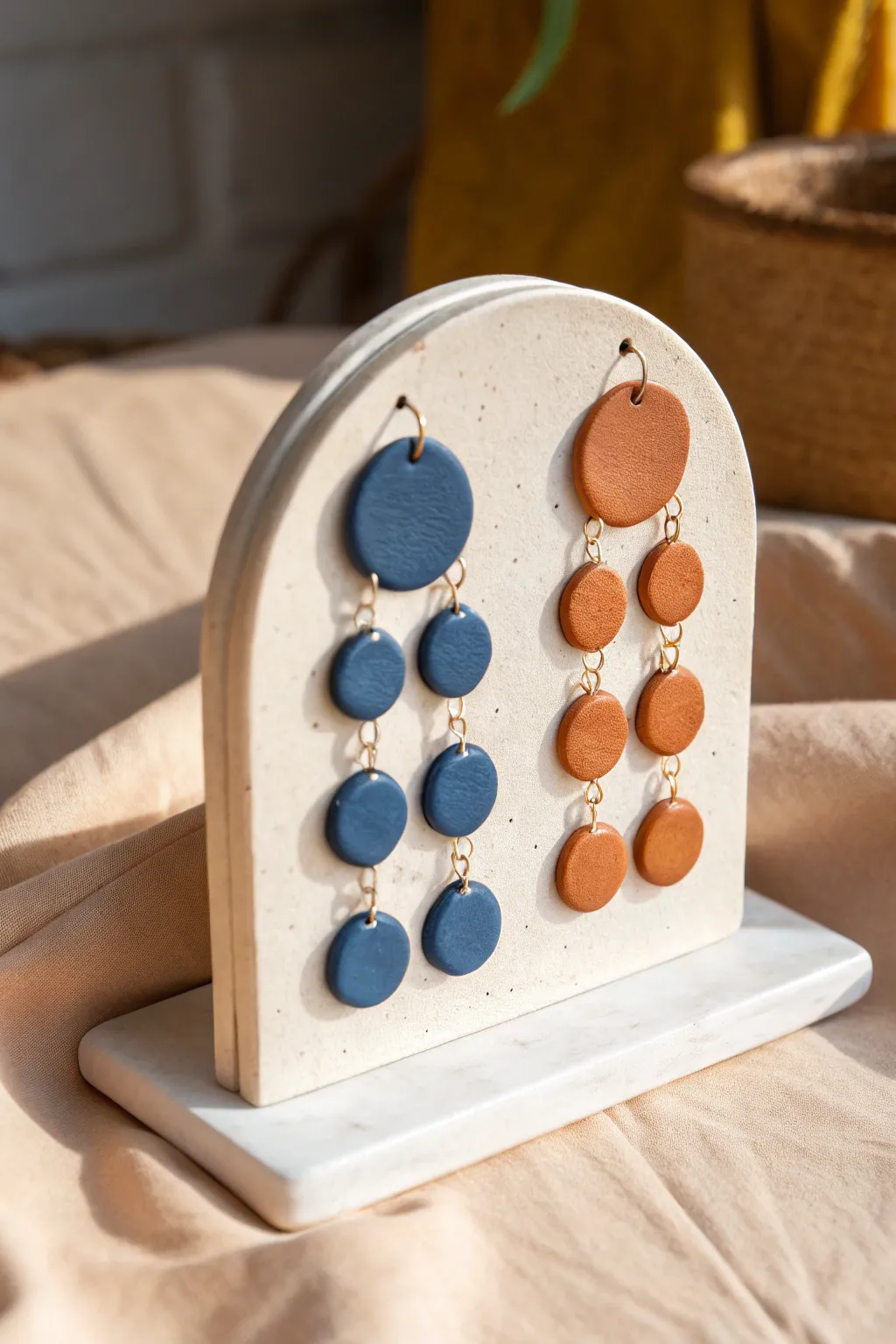 Minimal arched clay earring stand with bold earrings, chic handmade storage for any dresser.