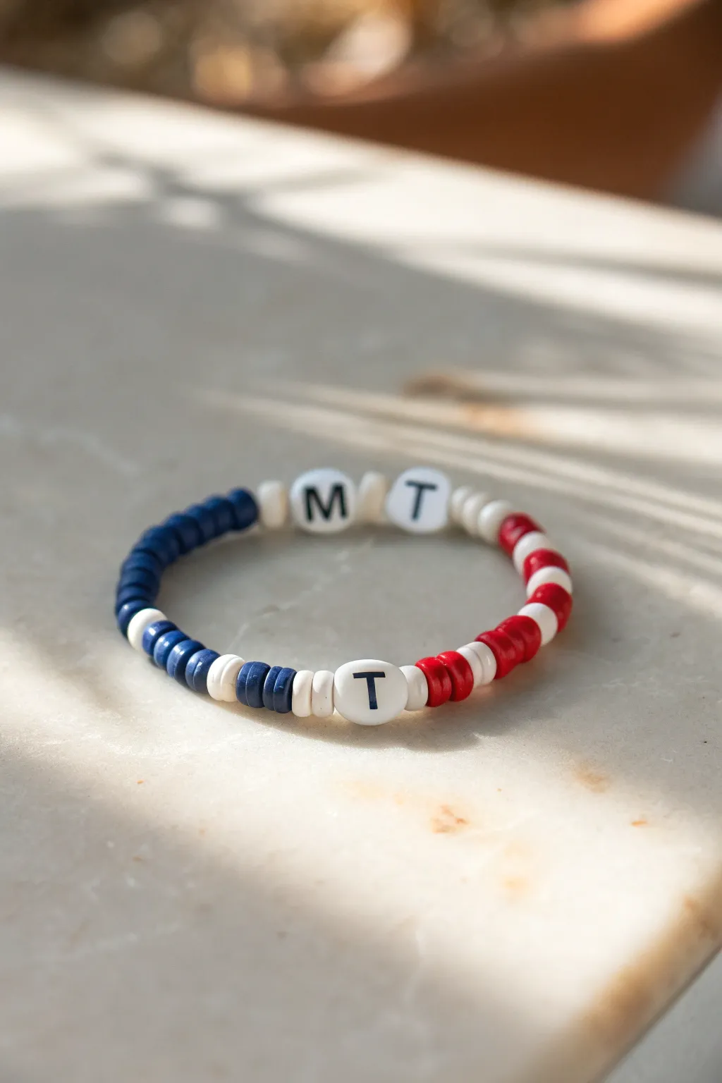Bold team-color heishi bracelet with centered initial beads, minimalist and handmade-ready.