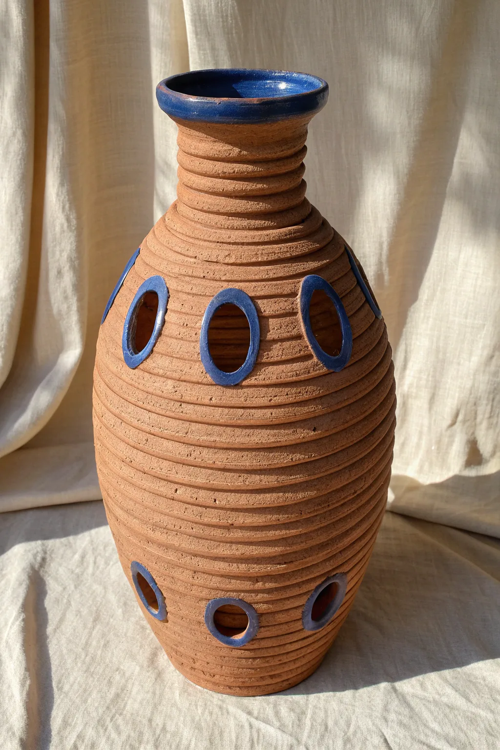 Cutout window coil vase with bold negative space and sunlight shadows, simple and striking.