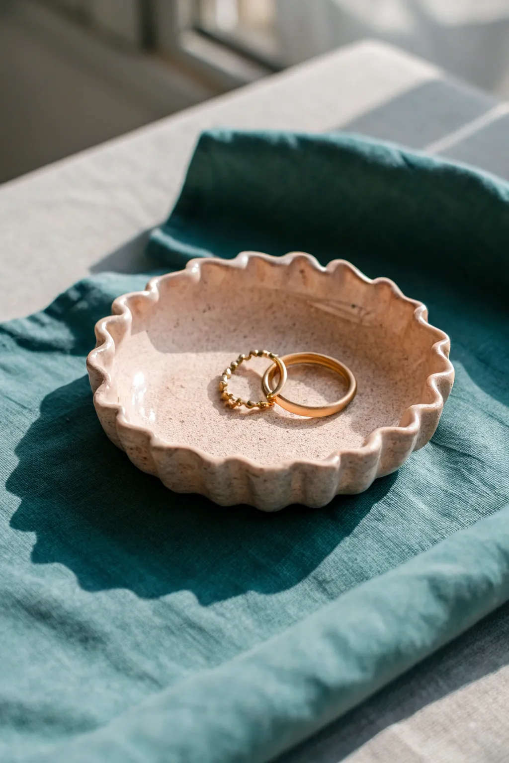 Ruffled pinch edge dish in warm clay tones, holding a few rings, minimalist and boho.