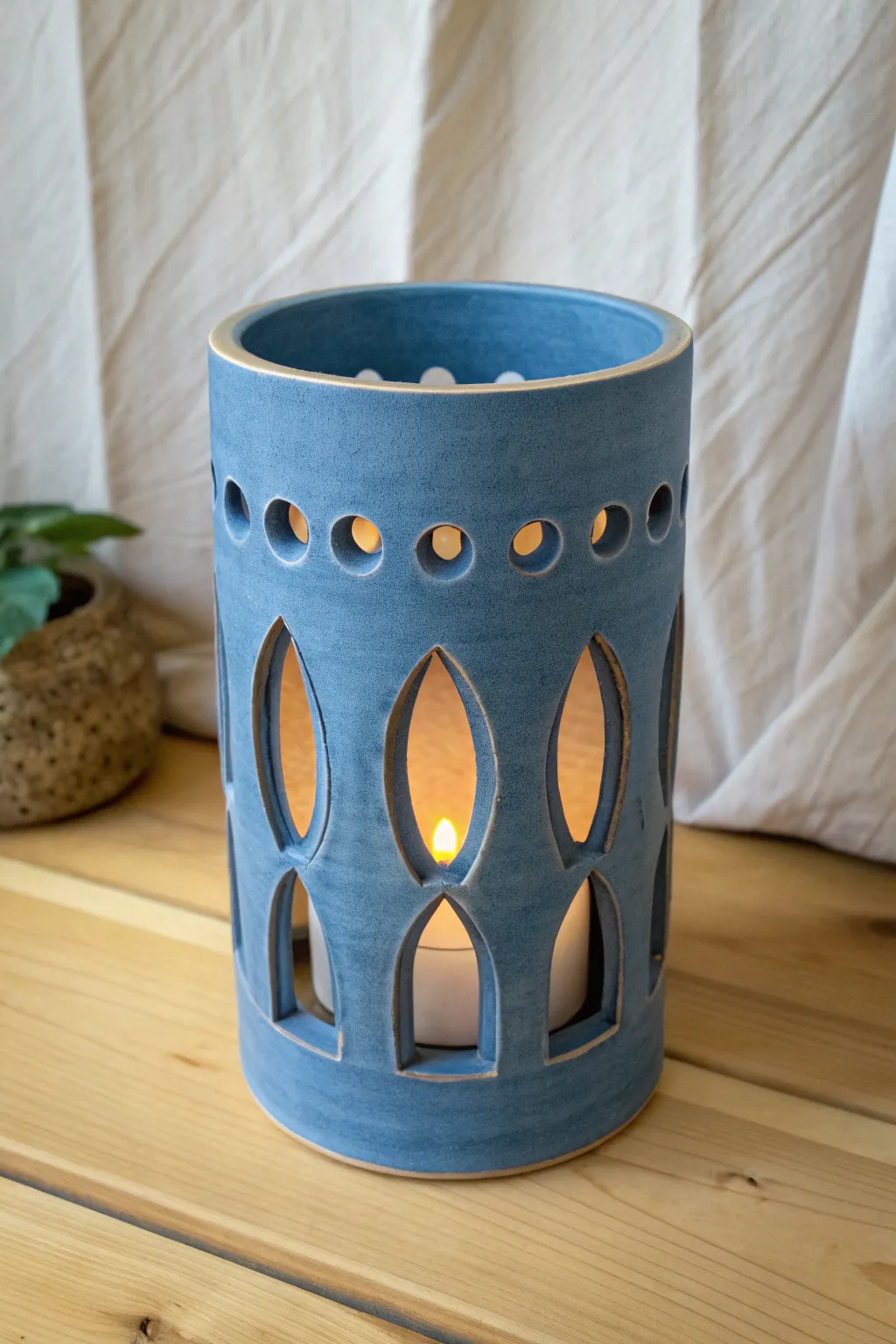 Two-layer clay luminary casting deep, dreamy shadows through a simple cutout sleeve.