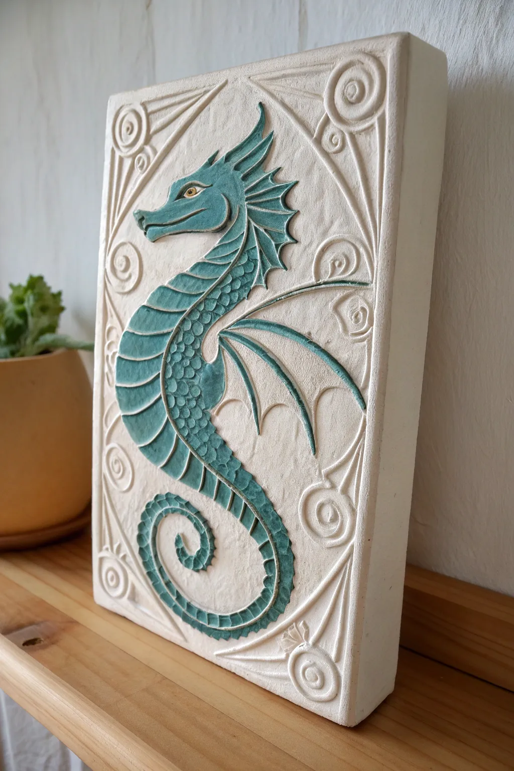 Coil-and-scale dragon relief panel in matte clay with bold teal accents and crisp shadow contrast.