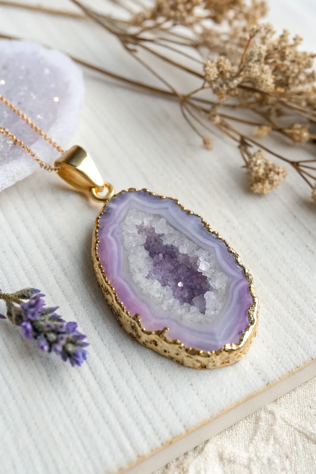 Lavender faux geode pendant with a sparkling crystal core, minimalist flat lay and boho warmth