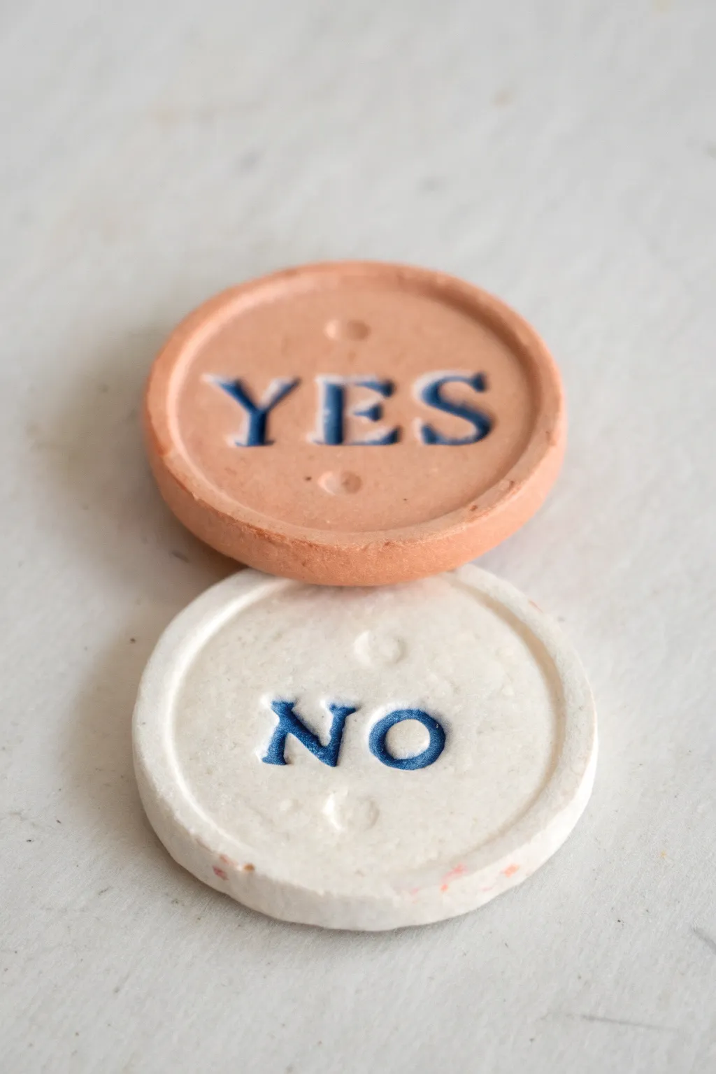 Handmade clay pocket tokens, YES and NO, a minimalist way to pick your next easy date idea.