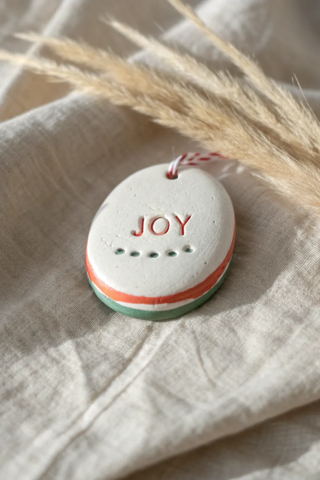 Stamped clay Easter egg with bold coral border and simple JOY imprint for minimalist spring decor