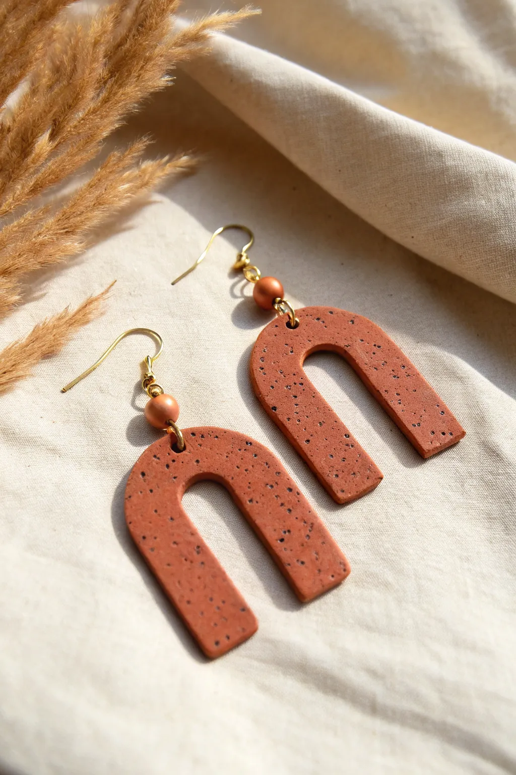 Modern negative-space polymer clay earrings in bold terracotta, minimalist and handmade.