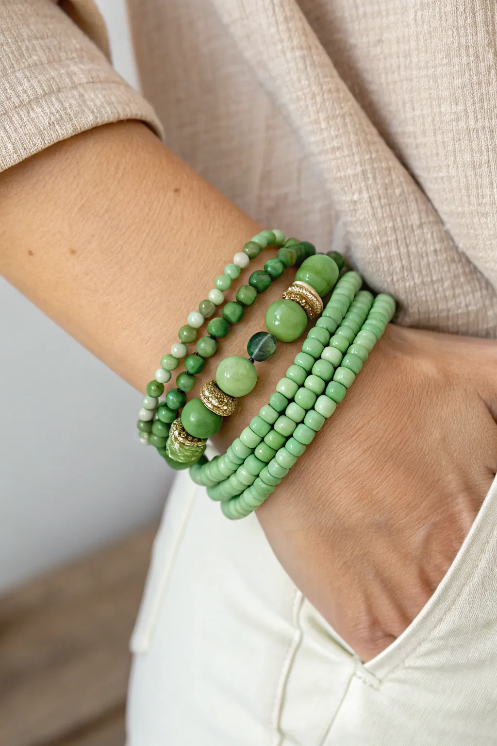 Layered green clay heishi with faceted and round beads for an easy mixed-texture stack.