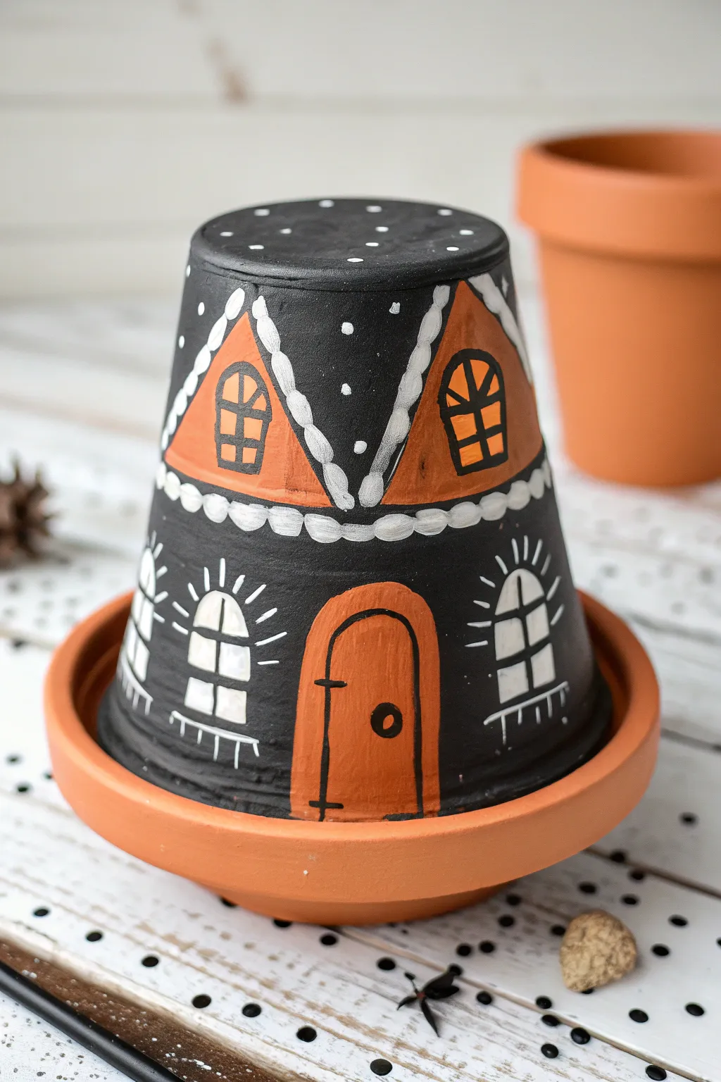 Upside-down clay pot haunted house with bold contrast and a tiny path base for Halloween charm