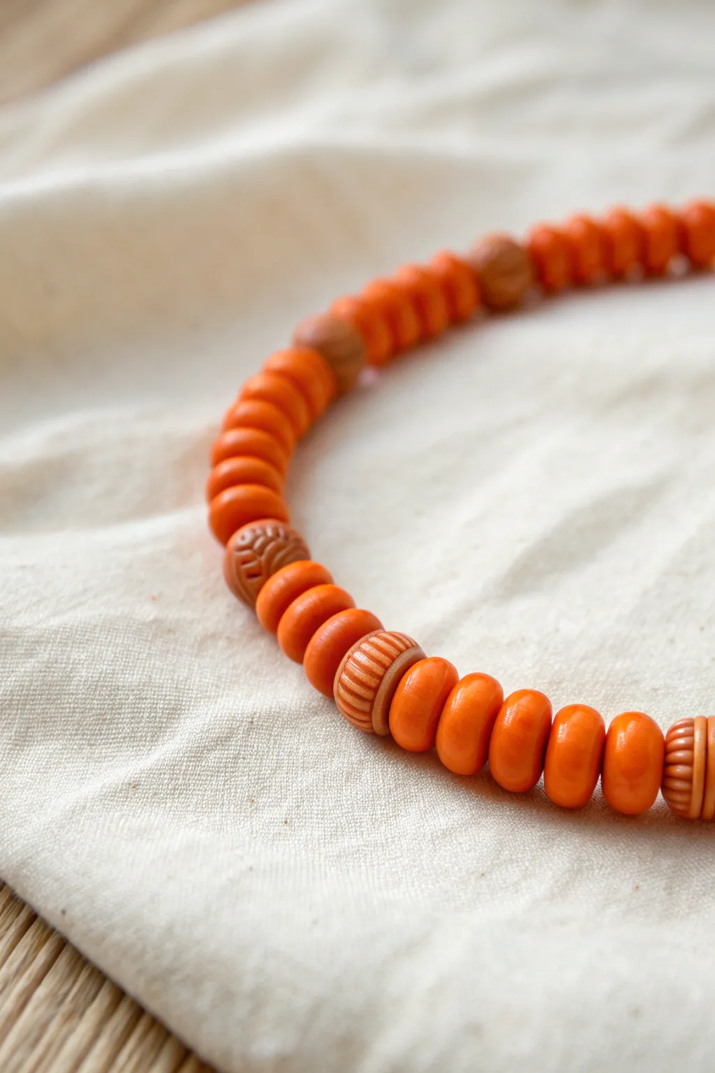 Textured orange clay beads add depth and a bold pop to a simple minimalist bracelet.