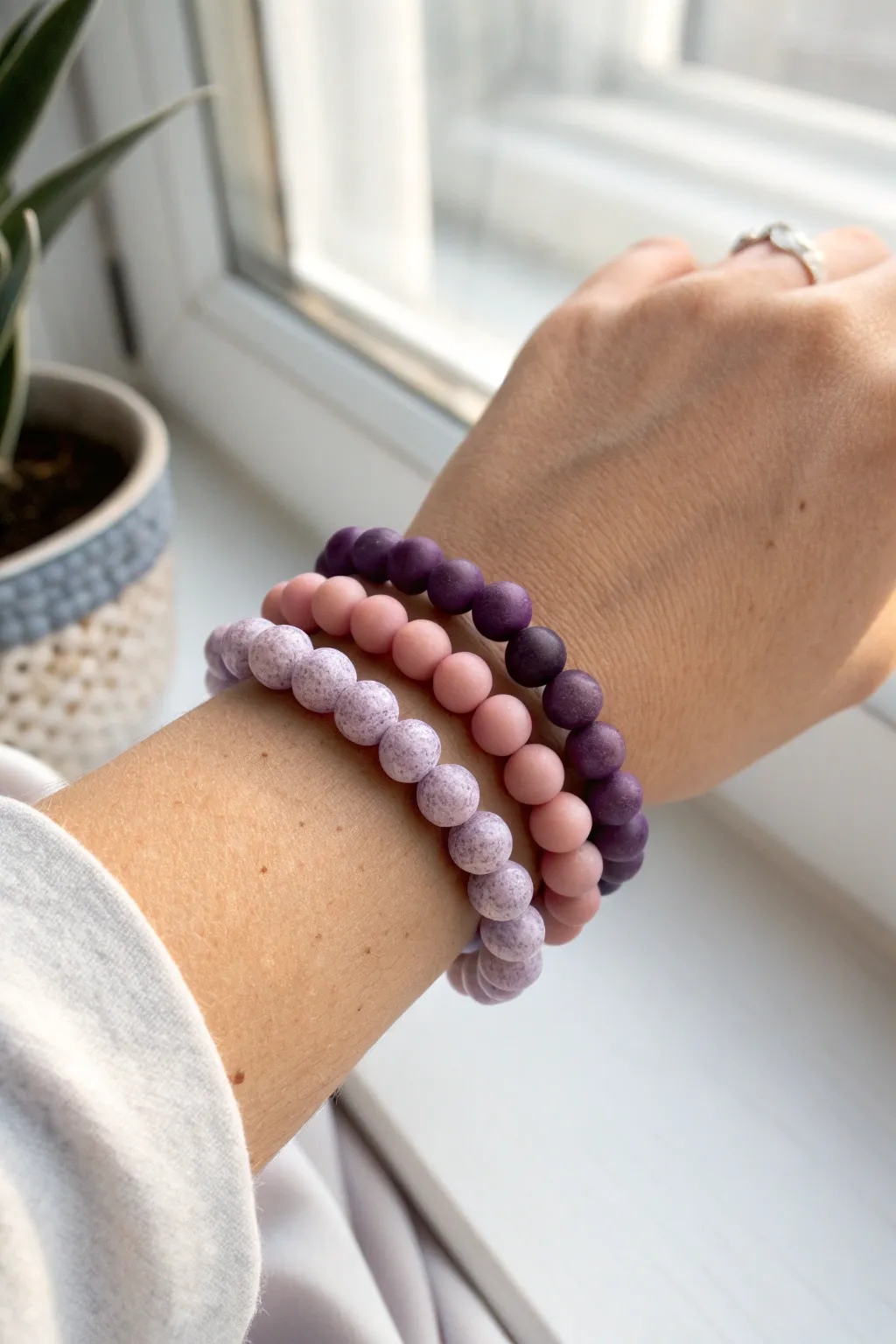 Stack your look with blush pink and deep purple clay bead bracelets, simple and bold together.