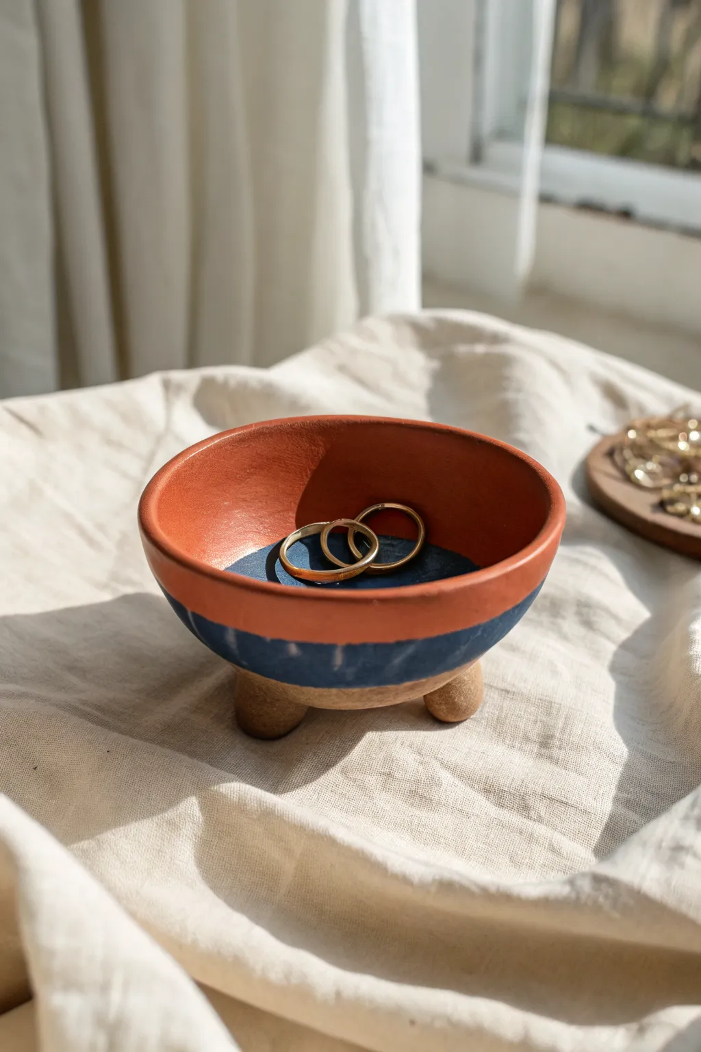 A tiny footed polymer clay bowl in terracotta and cobalt, perfect for rings and everyday treasures.