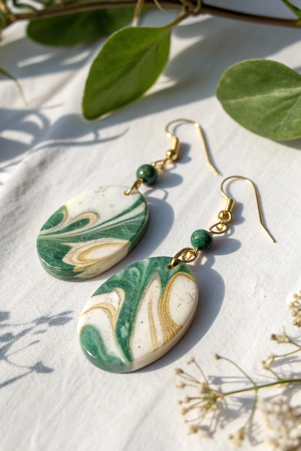 Faux jade swirl polymer clay earrings on white, minimalist yet bold and beautifully handmade.