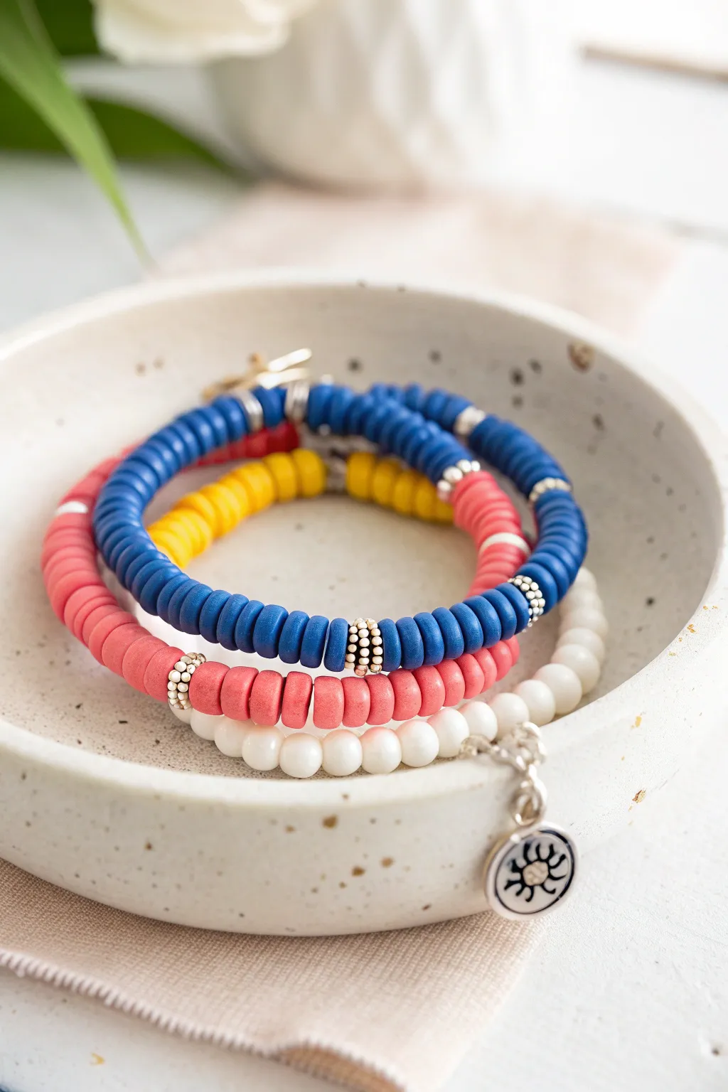 Preppy clay heishi bracelet stack with mixed bead shapes, tiny spacers, and one cute charm.
