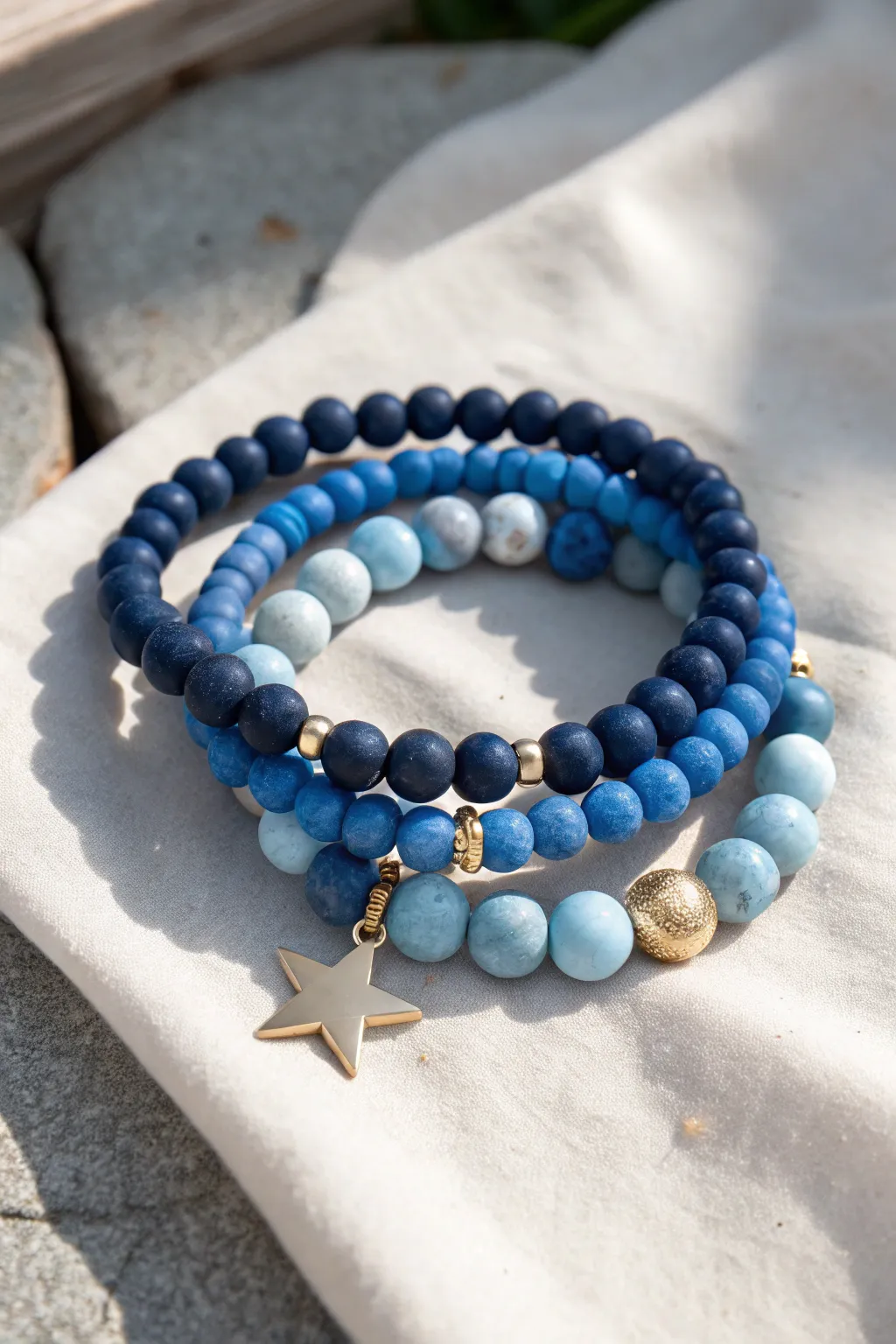 Preppy blue clay bead stack set with one standout charm, minimal Nordic style in bright sun