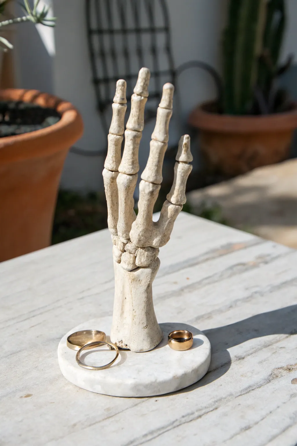 Spooky-chic bone-hand ring holder in matte clay, minimalist Halloween decor with bold contrast.