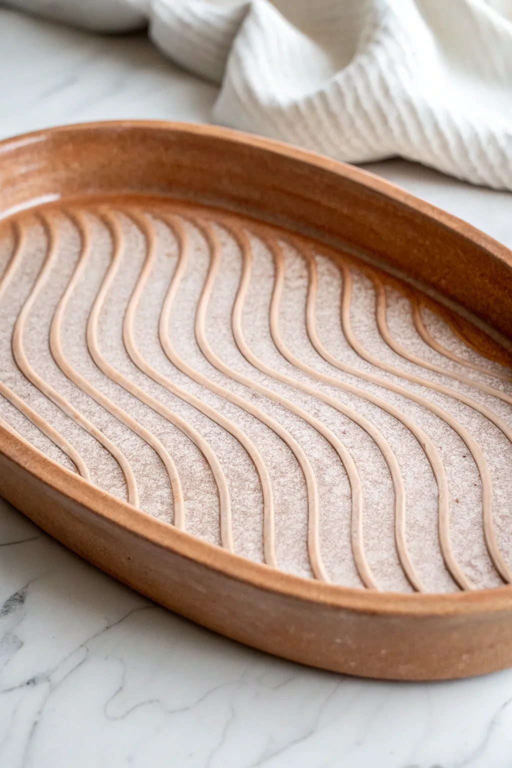 Rippled slab tray with a barely-there glaze, side-lit to highlight every handcrafted curve.