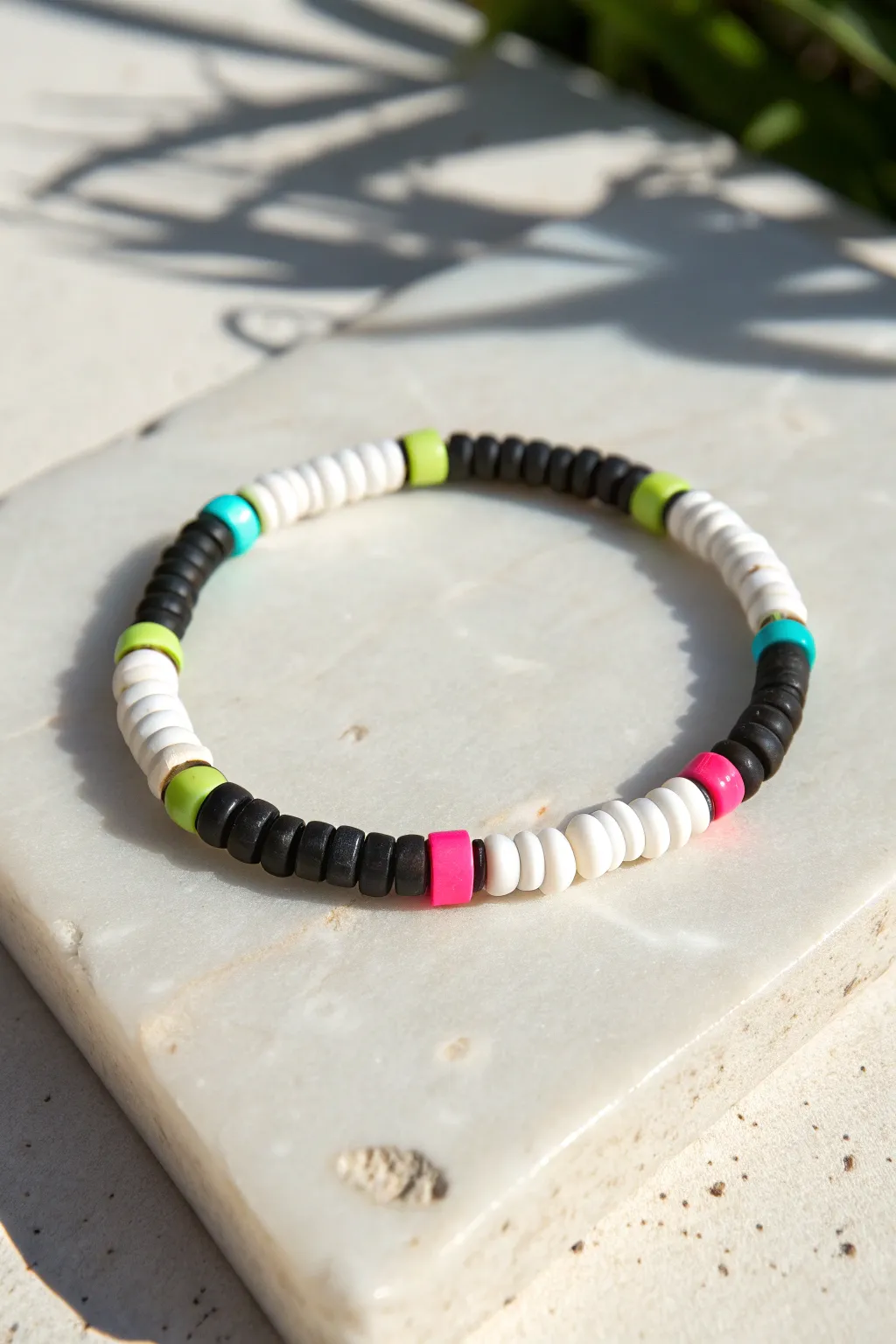 Black, white, and neon heishi bracelet that pops in summer sun with crisp minimalist shadows.