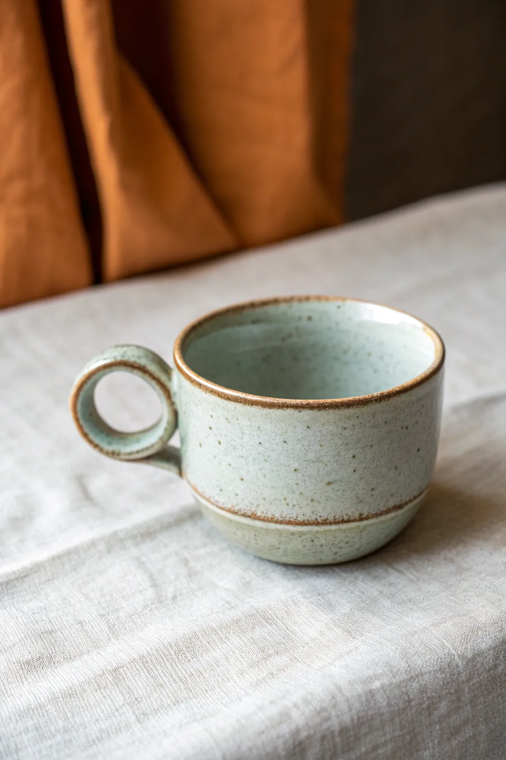 Minimal tea cup with a sculptural twist handle, clean glaze and bold contrast for cozy styling.