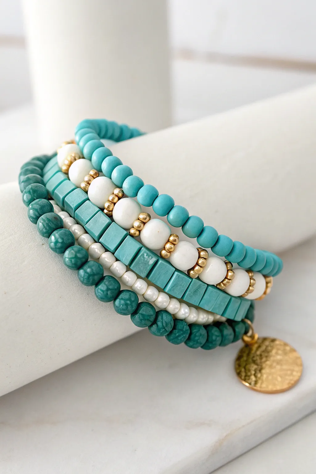 Mismatch teal bracelet stack with heishi, pearls, cubes, and shell charm for easy boho minimal style.