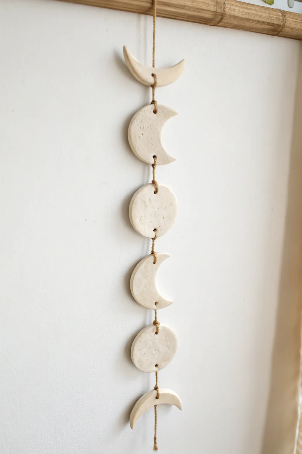 Soft neutral air dry clay moon phases on linen cord, a simple dreamy wall hanging