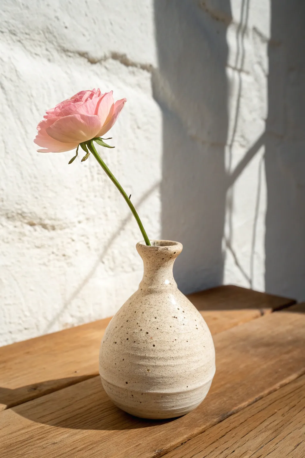 Tiny coil bud vase with handmade charm, styled with one stem in bright Scandinavian light