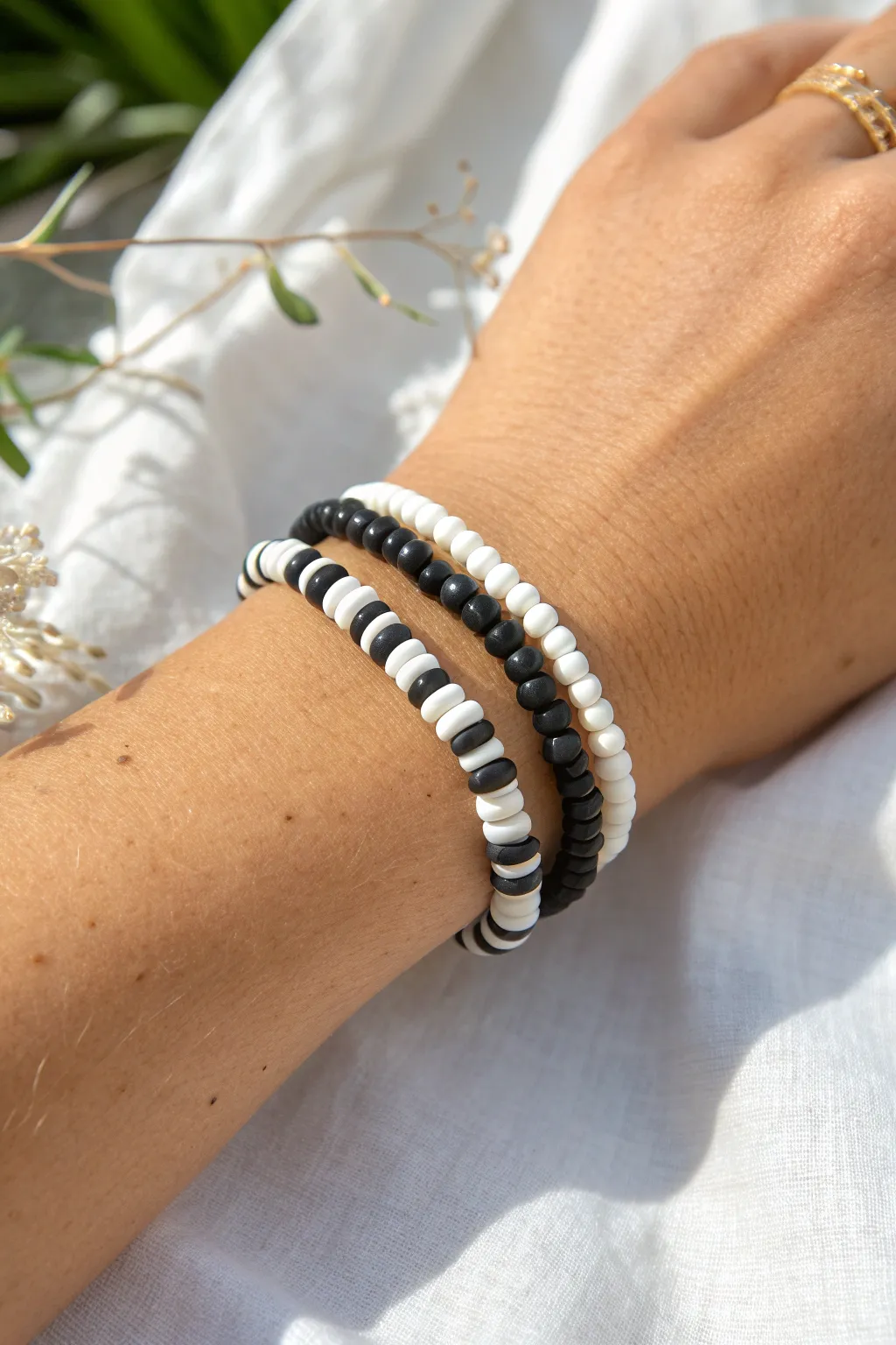 Black and white heishi bracelet with tiny round accents for a clean, modern boho stack.