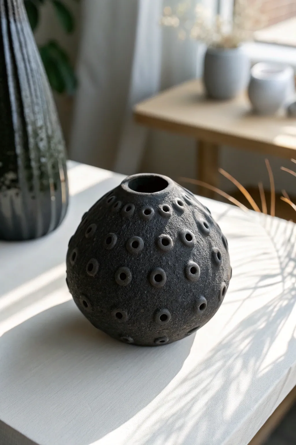 Minimal black clay cellular sculpture with softly highlighted texture for bold, modern contrast.