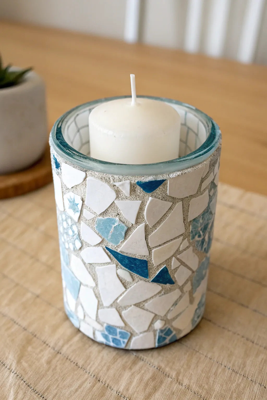 Blue-and-white china shard mosaic candle holder with smooth grout, minimalist and touch-safe.