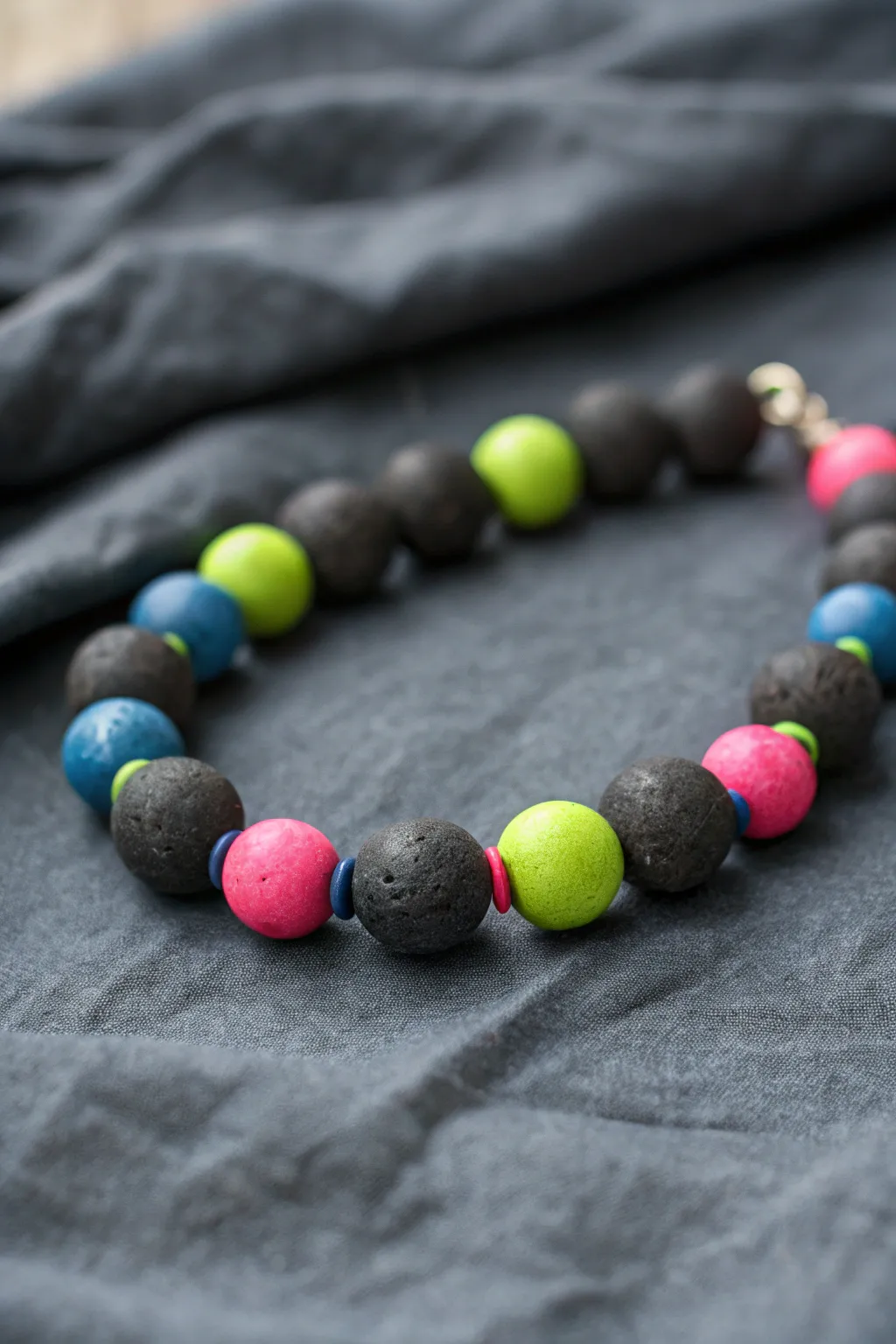 Moody charcoal clay beads with neon pops create bold contrast, no white needed.