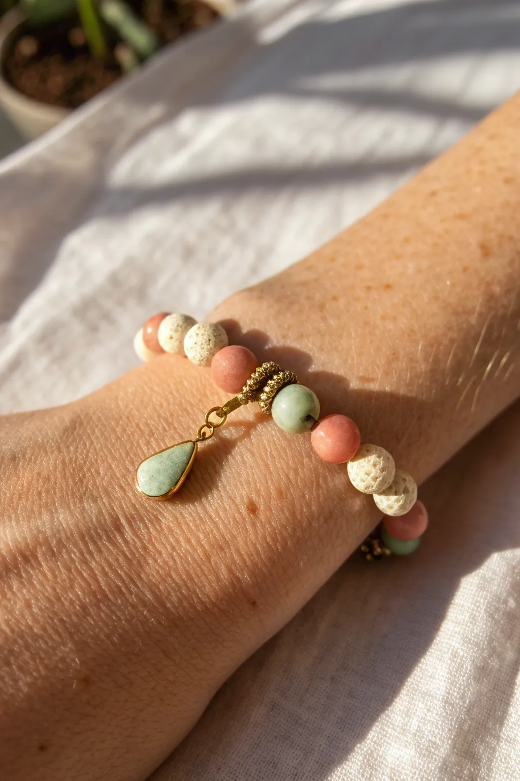 Minimal clay bead bracelet with a centered charm drop, framed by soft heishi beads for boho polish.