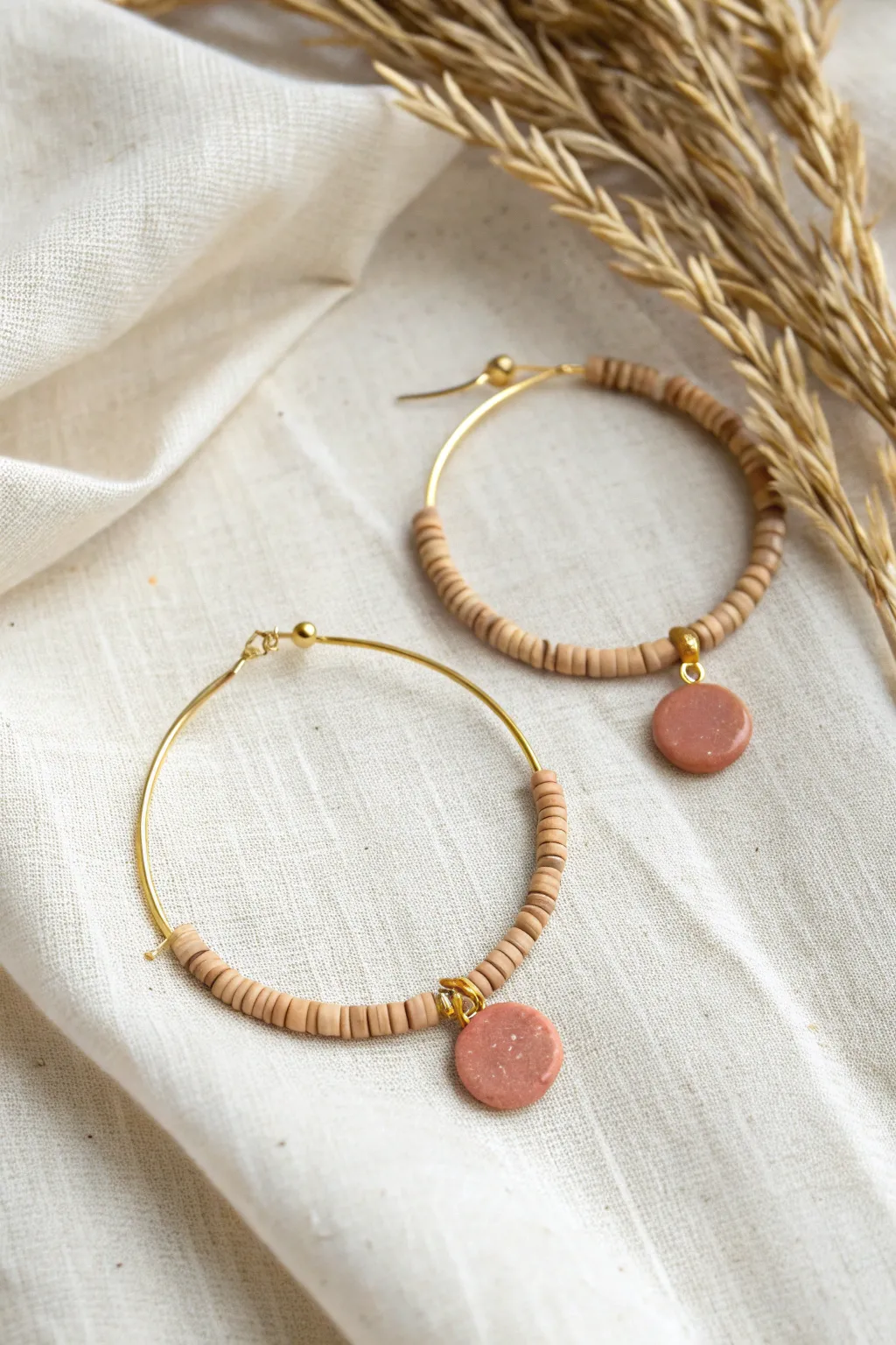 Minimal clay bead hoop earring with tiny heishi beads and one bold disc bead centerpiece.