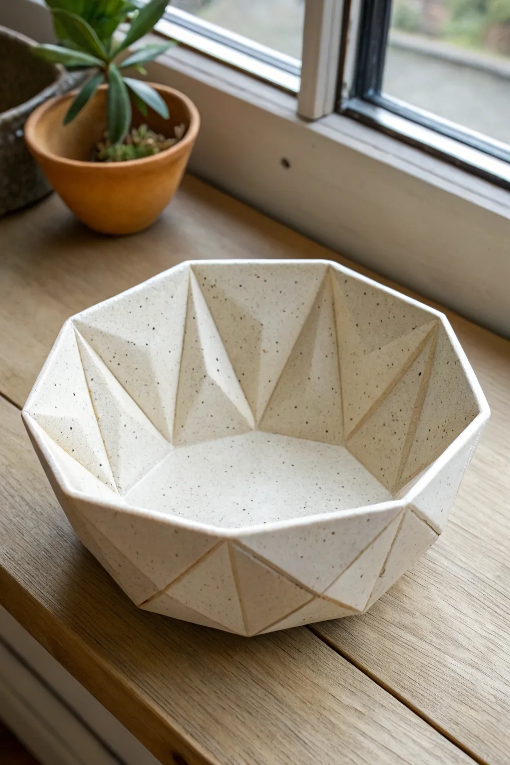 Faceted origami-style clay bowl in warm speckled stoneware, minimalist geometry with boho calm.