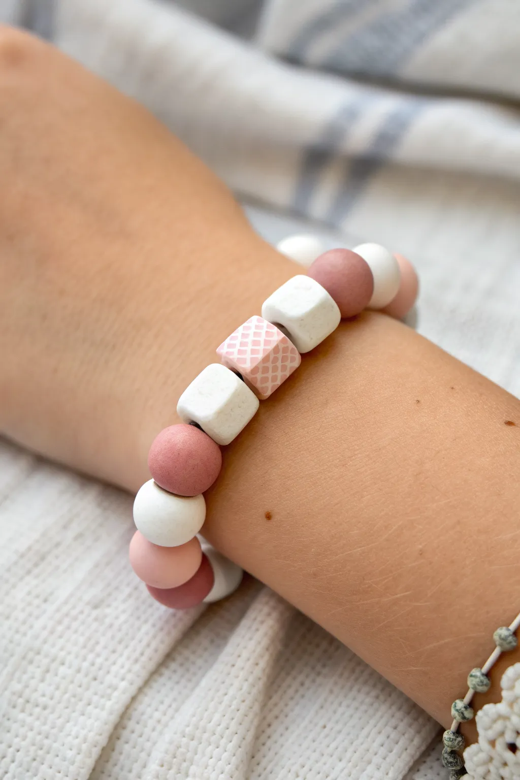 Soft checkerboard clay bracelet in white and blush, minimalist boho style with handmade charm.