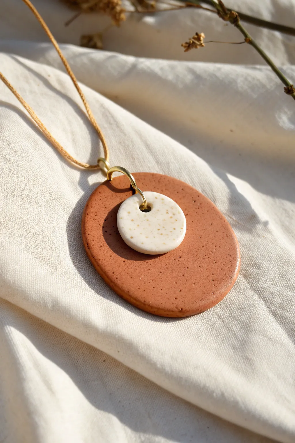 Minimal clay spinner pendant with gentle movement, warm neutrals, and crisp Scandinavian contrast
