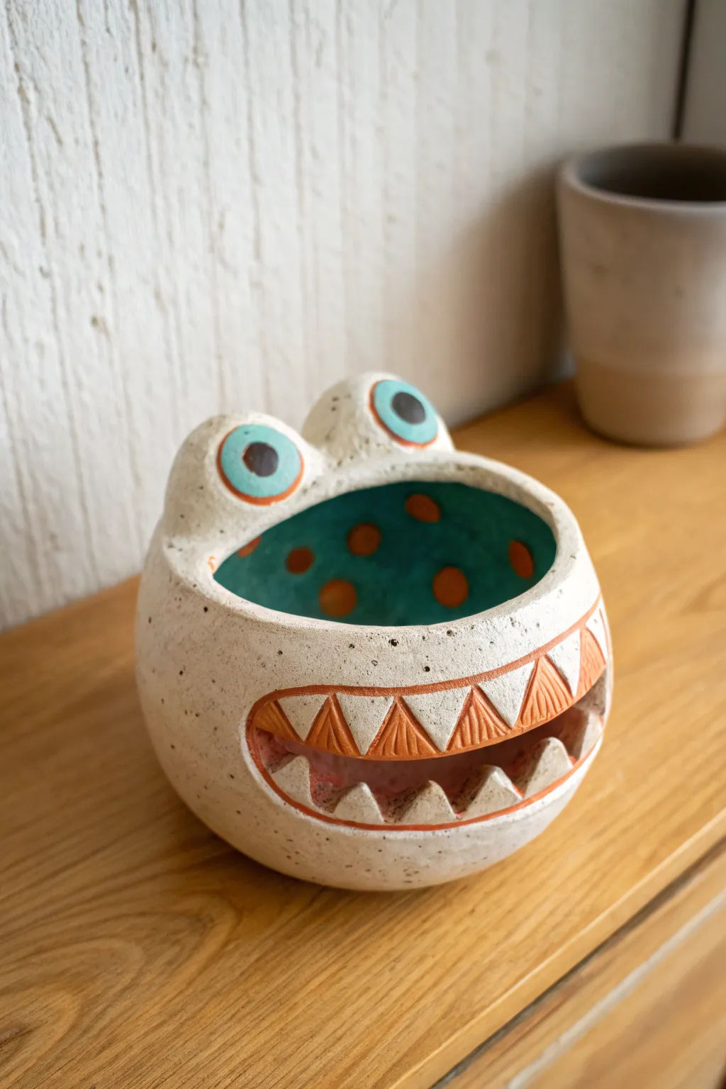 Goofy monster mouth pinch pot: simple teeth, bold eyes, and cozy Scandinavian desk charm.