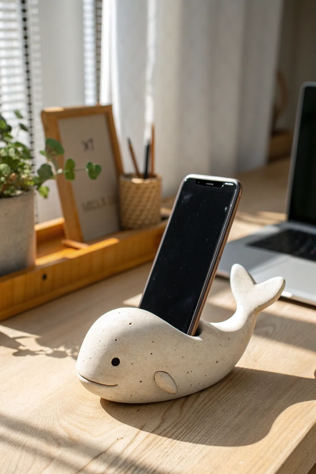 A sweet mini clay whale that holds your phone upright, perfect for a calm minimalist desk.