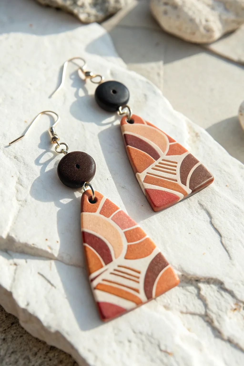 High-contrast mokume gane dangles paired with matte faux lava charms for bold minimal style
